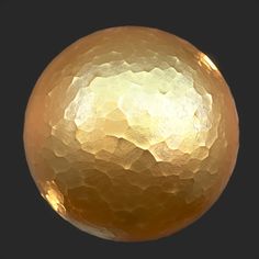 an abstract golden sphere on a black background with some light reflecting off it's surface