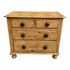 a wooden dresser with three drawers and two knobs on the front, against a white background