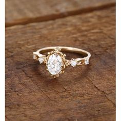 a close up of a gold ring on a wooden surface with a diamond in the center