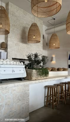 an open kitchen with lots of counter space and hanging lights above the counter area, along with stools