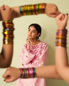 a woman standing in front of three bracelets