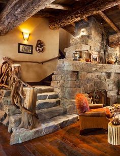 a rustic living room with stone fireplace and wood flooring is pictured in this image