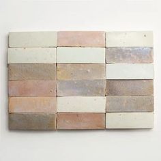 a white wall with several different colored tiles on it