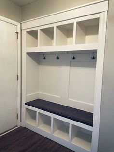 an empty room with white shelves and benches