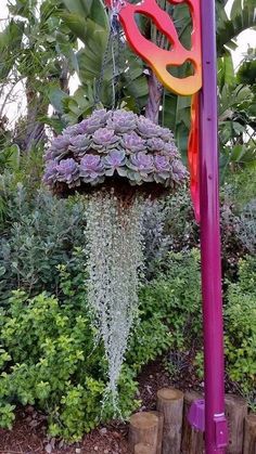 a purple pole with flowers hanging from it's sides and the text use the pinterest app