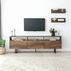 a living room with a television and some shelves on the wall above it that have plants in them