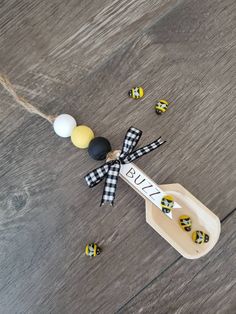 a wooden spoon with black, white and yellow decorations next to it on a table