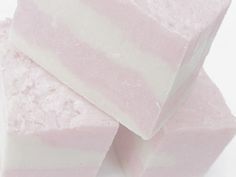 three pieces of pink and white soap stacked on top of each other in front of a white background