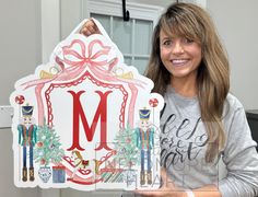 a woman holding up a sign with the letter m on it's front and side