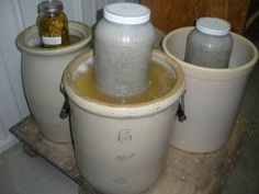 three white buckets filled with yellow liquid