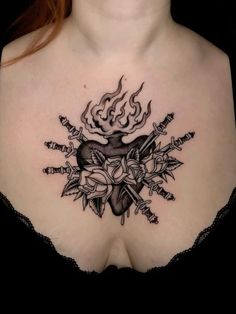 a woman's chest with tattoos on it and an arrow in the shape of a heart