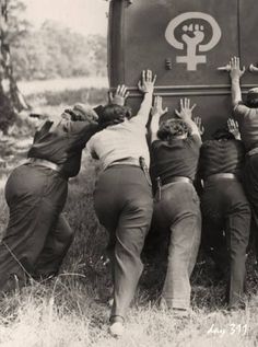 four people reaching into the trunk of a truck with their hands up in front of them