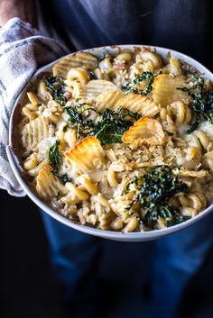 a bowl filled with pasta and spinach on top of a table