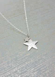 Sterling silver necklace with two star charms, the larger star is finished in a hammered effect Which catches and reflects the light, and the smaller one is polished to a high shine. All elements are 925 sterling silver. Large star measures 2cm (20mm) Small star 8mm. This comes on a delicate sterling silver chain, 16 or 18 inch please select when ordering. All Karmasilver Jewellery is handmade in the UK using traditional silversmithing techniques. Hammered moon & Star necklace https://www.etsy.c Cheap Silver Necklaces With Star Charm, Affordable Silver Star Charm Necklace, Silver Star Necklace, Long Stone Necklace, Honeycomb Necklace, Handmade Silver Jewellery, Star Necklace Silver, Silver Choker, Moon Jewelry