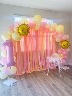 a room decorated with balloons, streamers and decorations for a 1st birthday party or baby's first birthday