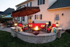 a fire pit surrounded by chairs and an umbrella