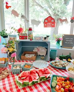 a table topped with watermelon slices and other foods on top of a checkered table cloth