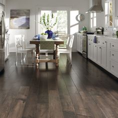 the kitchen is clean and ready to be used for dinner or lunchtime, with white cabinets and wood floors