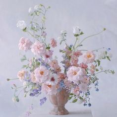 a vase filled with lots of pink and white flowers