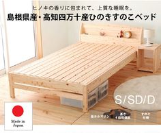 a wooden bed sitting on top of a hard wood floor next to a white rug