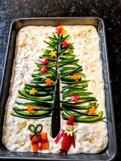 a christmas tree made out of green beans and carrots on top of a pan