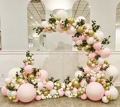 the balloon arch is decorated with pink, white and gold balloons