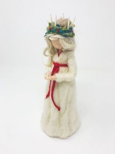 a white figurine with a red ribbon around it's neck