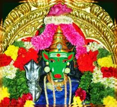 an idol with flowers around it in front of a gold frame and red, white, yellow, and green colors