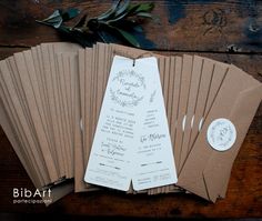 some brown and white paper tags on top of each other next to a wooden table