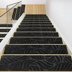 the stairs are decorated with black carpet and wood treads, along with white walls