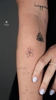 a woman's arm with a flower tattoo on the left side of her arm