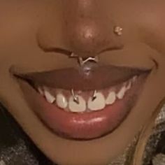 a woman with piercings on her nose smiling