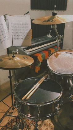 a drum set up in front of a piano