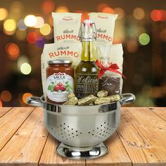 a large metal bowl filled with food and condiments on top of a wooden table