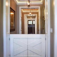 an open door leading to a hallway with two pictures on the wall and a chandelier hanging from the ceiling