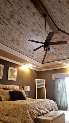 a bedroom with a bed, mirror and ceiling fan in the middle of the room