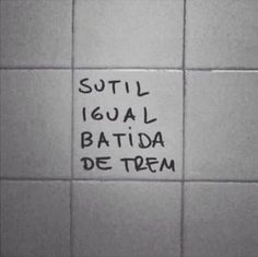 graffiti written on the side of a white tiled wall in a public restroom, saying'still igual batida de term '