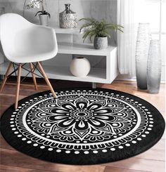 a black and white rug with an ornate design on the floor next to a chair