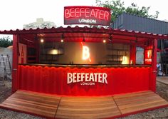 a food stand with red walls and wooden benches in front of it, along with a sign that reads beefeaser london