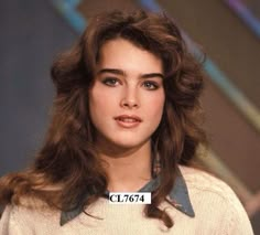 an old photo of a woman with brown hair and blue eyes, wearing a sweater