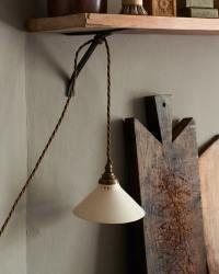 a lamp hanging from the side of a wall next to wooden planks and other items