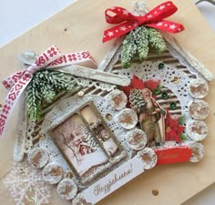 an altered christmas ornament is displayed on a wooden table with ribbon and decorations