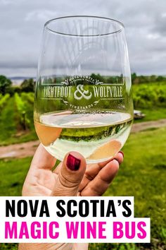 a hand holding up a wine glass with the words, nova scotta's magic wine bus