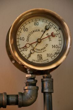 a close up of a pressure gauge on top of a metal pipe with nozzles