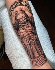 a man's arm with a tattoo on it and an image of a statue