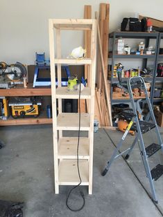 a wooden shelf in a garage with tools on the floor and shelves next to it