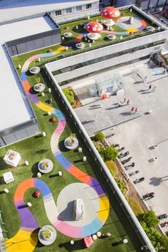 an aerial view of a building with grass on the roof and colorful circles painted on the ground