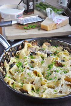 a pan filled with pasta and mushrooms on top of a table