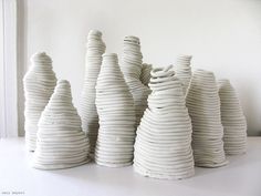 several white vases sitting next to each other on a table