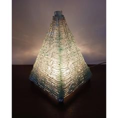 a very tall glass tower sitting on top of a wooden table under a cloudy sky